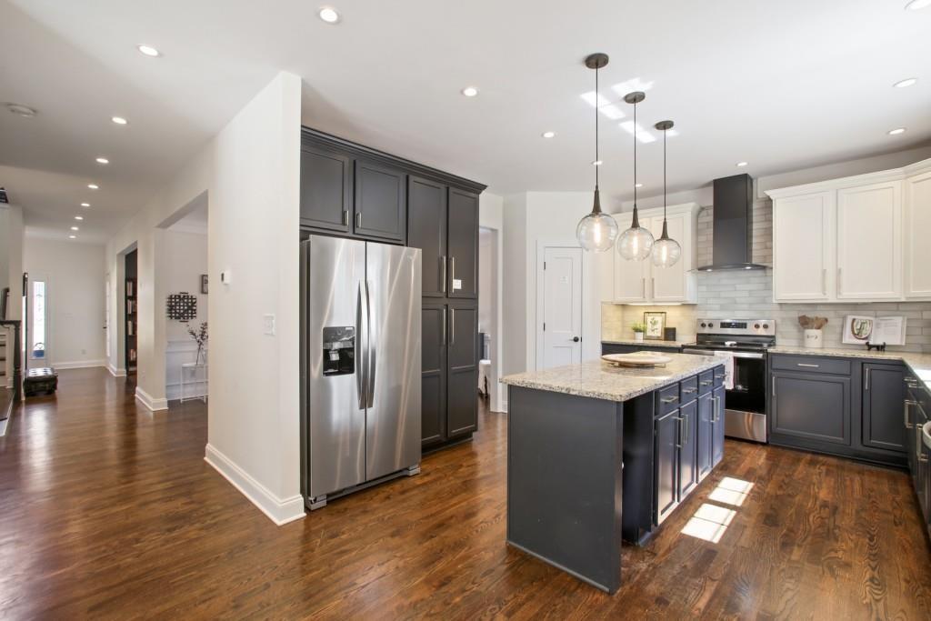 3761 Falls Trail Winston, GA 30187 - Photo 11 of 45 a kitchen with stainless steel appliances granite countertop a refrigerator a sink dishwasher a stove and white countertops with wooden floor