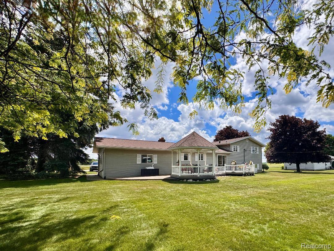 6686 South Schott Road Mayville, MI 48744 - Photo 9 of 25 Expansive green lawn with a white gazebo, multi-level deck, and mature trees