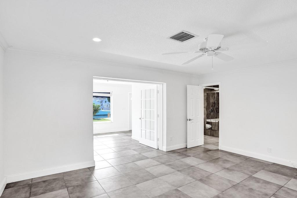 2632 Southeast 10th Court Pompano Beach, FL 33062 - Photo 31 of 49 an empty room with a ceiling fan and a rug