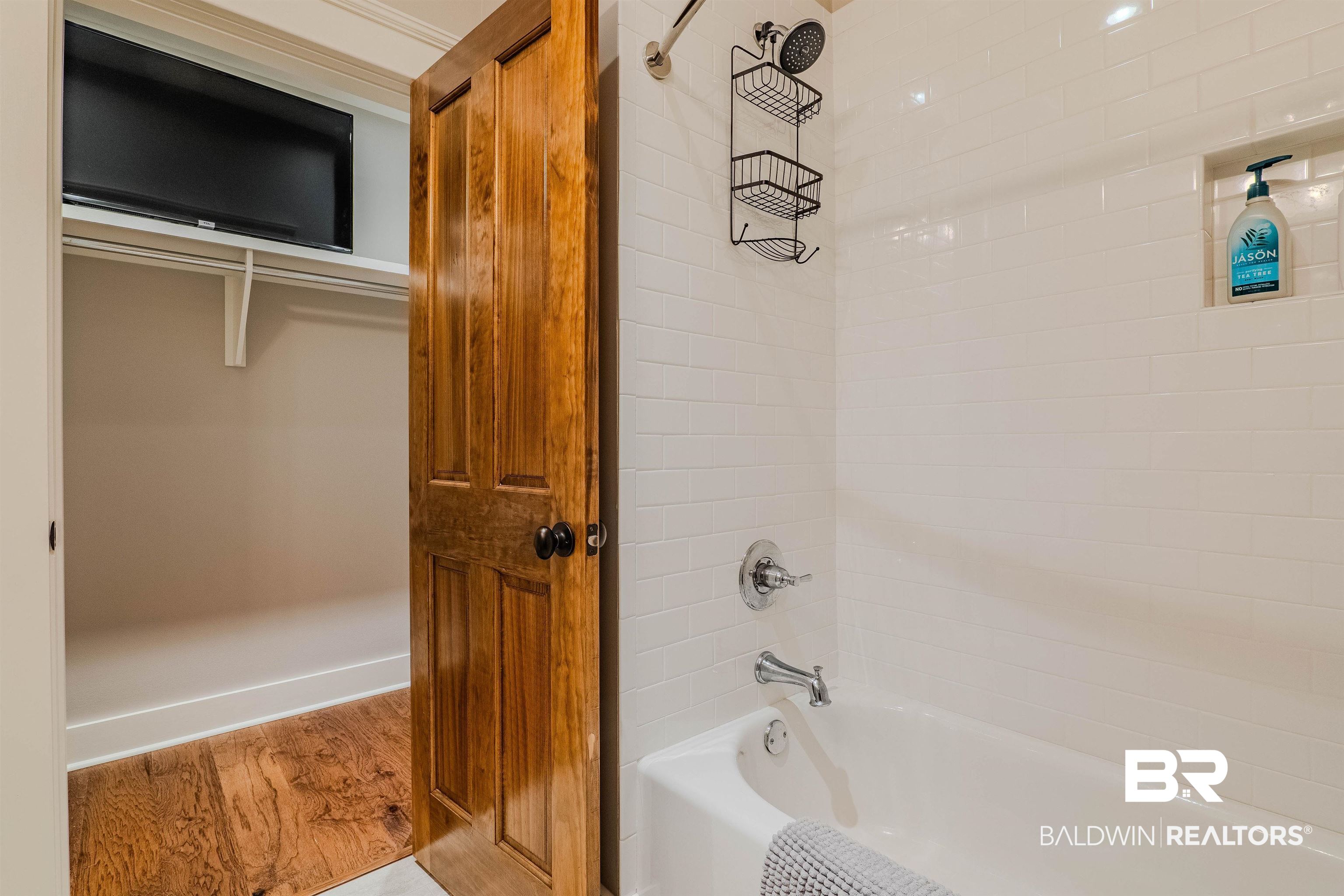 708 Manning Place Fairhope, AL 36532 - Photo 35 of 58 Bathroom with hardwood / wood-style flooring and tiled shower / bath