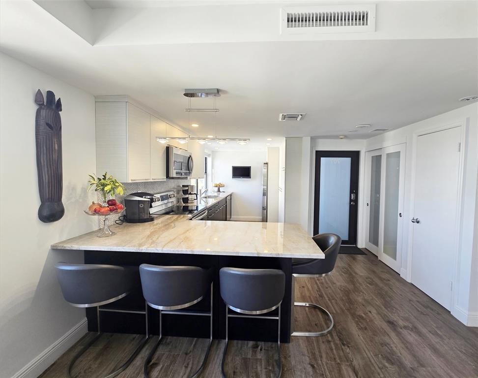 1401 North Riverside Drive, Unit 707 Pompano Beach, FL 33062 - Photo 6 of 32 a view of a dining room with furniture and wooden floor