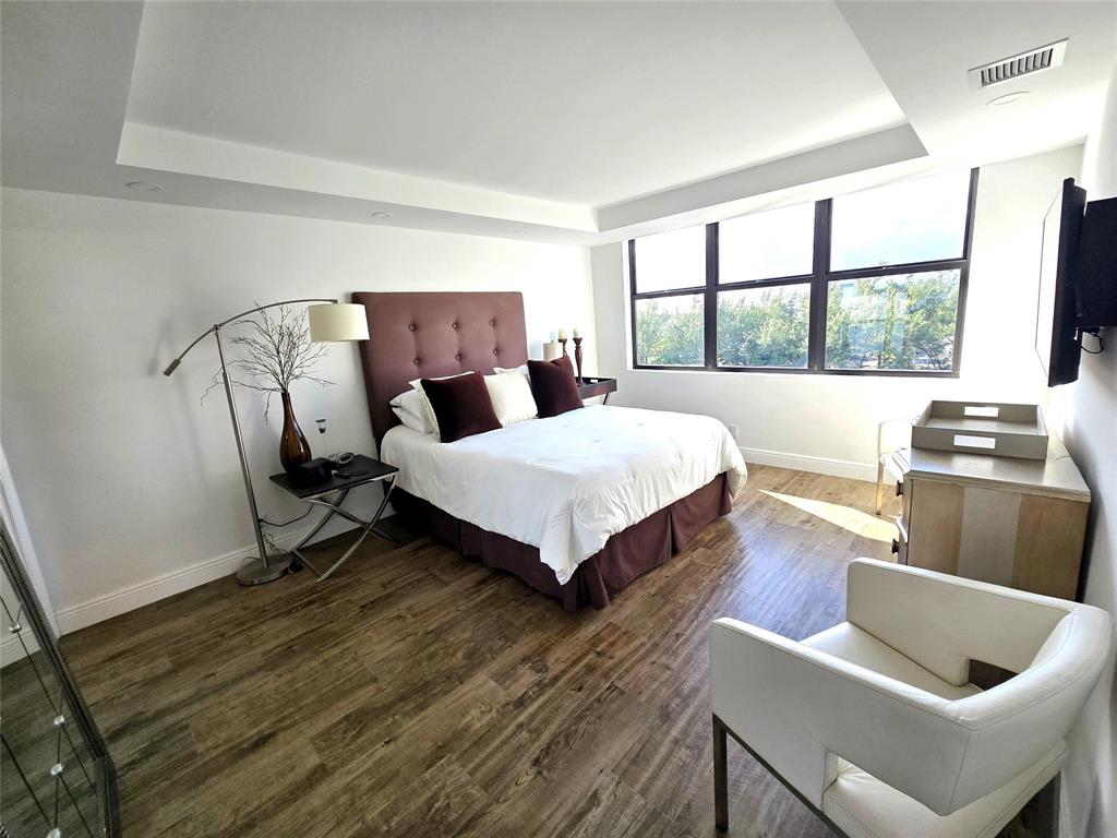 1401 North Riverside Drive, Unit 707 Pompano Beach, FL 33062 - Photo 8 of 32 a bedroom with a bed and wooden floor