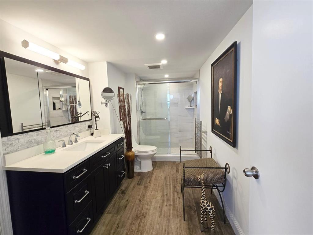 1401 North Riverside Drive, Unit 707 Pompano Beach, FL 33062 - Photo 10 of 32 a bathroom with a double vanity sink a toilet a mirror and shower