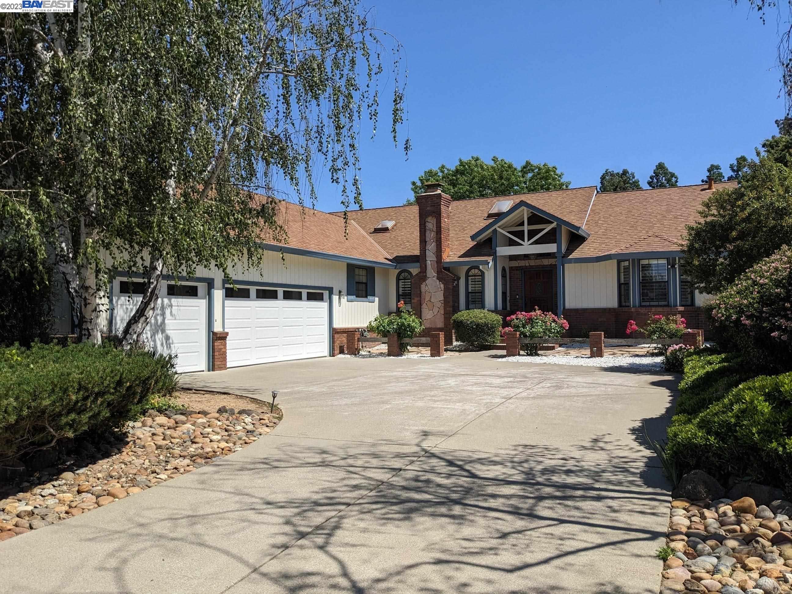 a front view of a house with yard and trees