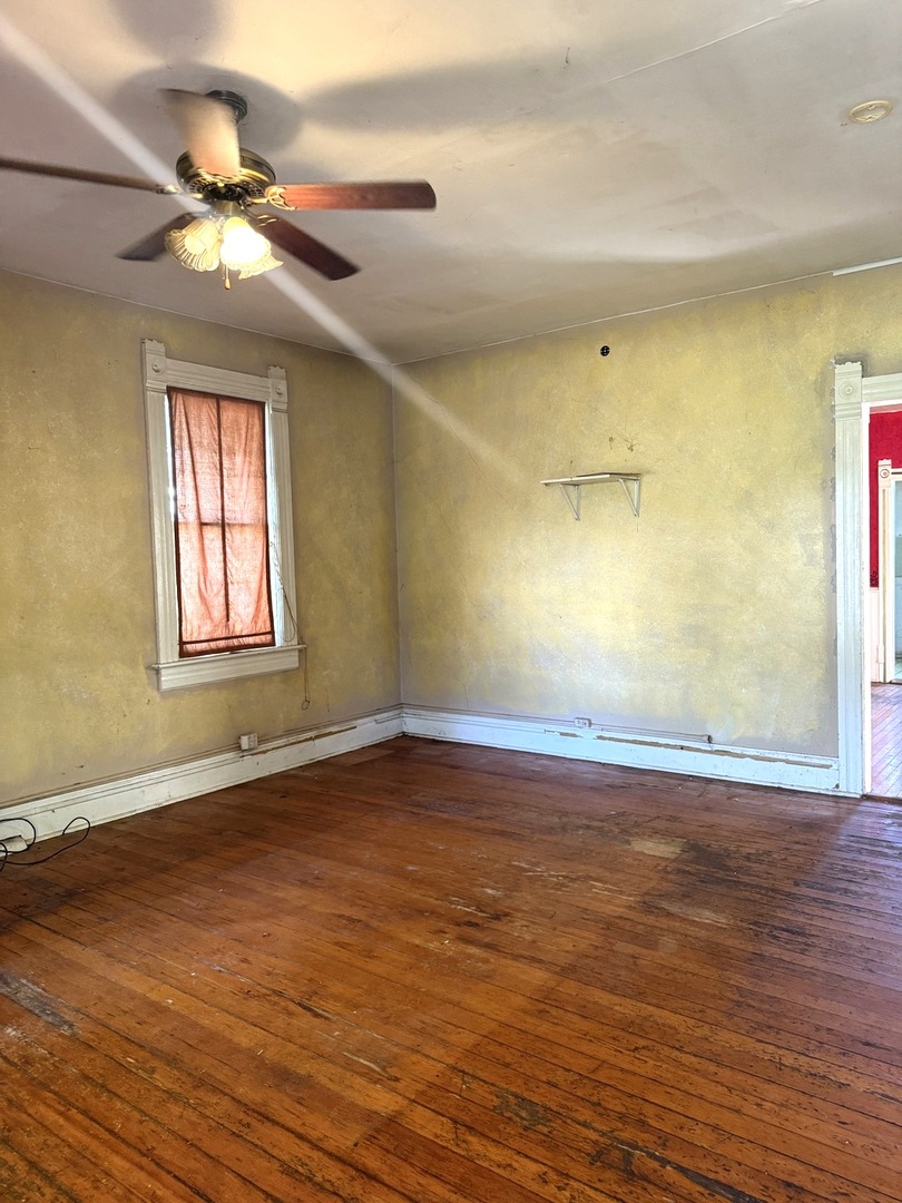 574 Herman Street Crete, IL 60417 - Photo 6 of 18 a view of a room with wooden floor and a ceiling fan