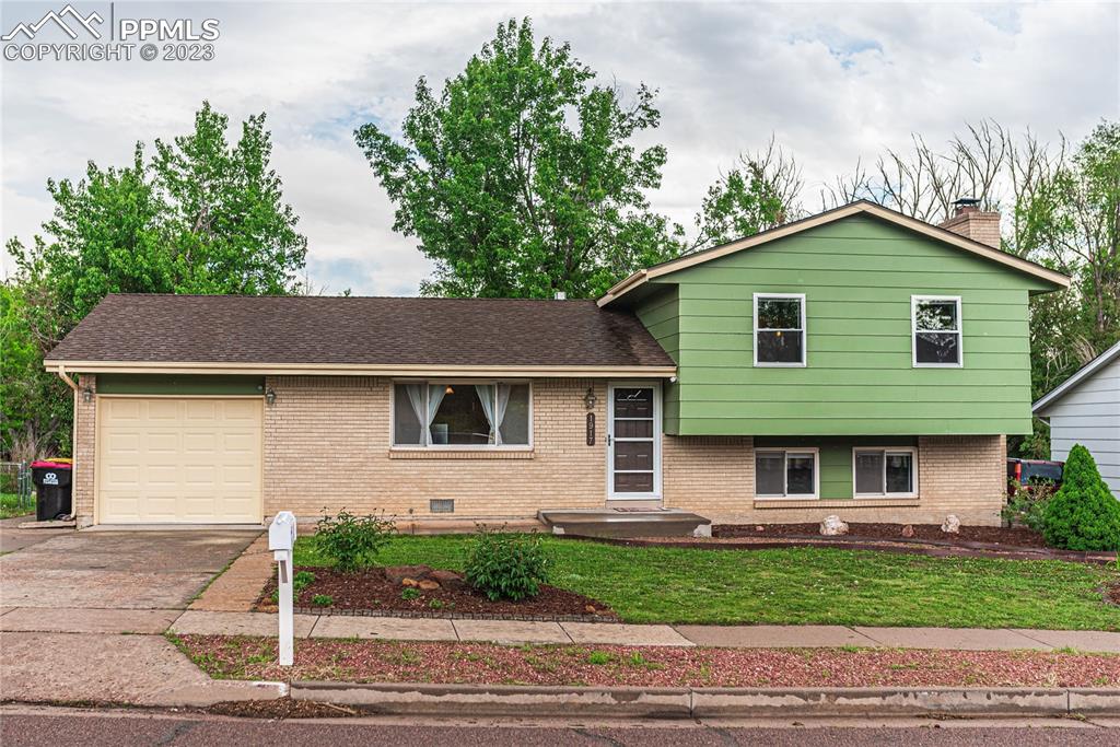 1917 Wooten Road Colorado Springs, CO 80915 - Photo 1 of 35 a front view of a house with a garden