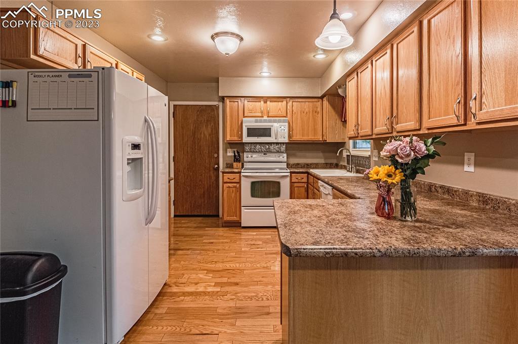 1917 Wooten Road Colorado Springs, CO 80915 - Photo 12 of 35 a kitchen with stainless steel appliances granite countertop a refrigerator a stove and a sink