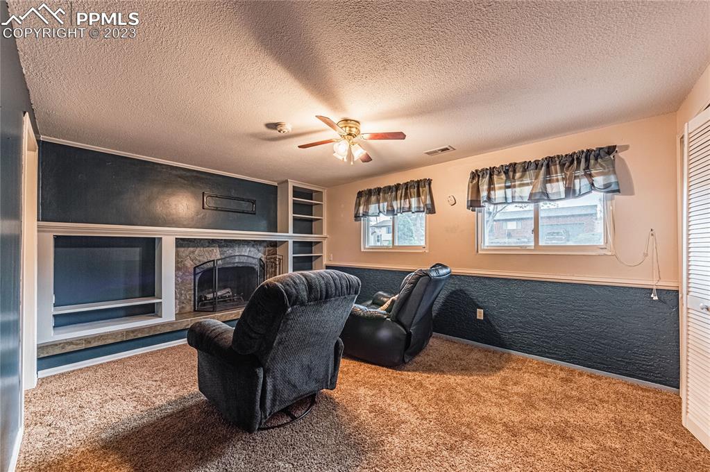 1917 Wooten Road Colorado Springs, CO 80915 - Photo 13 of 35 a living room with furniture a ceiling fan and a window