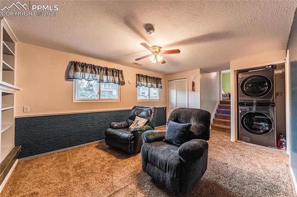 1917 Wooten Road Colorado Springs, CO 80915 - Photo 14 of 35 a living room with furniture a chandelier and a window