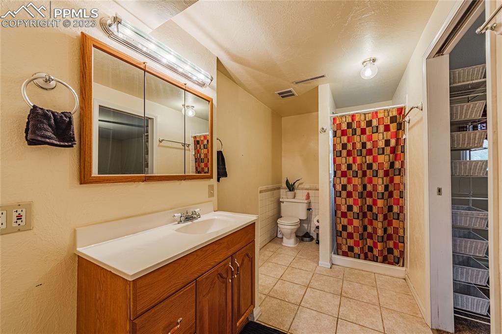 1917 Wooten Road Colorado Springs, CO 80915 - Photo 17 of 35 a bathroom with a sink toilet and shower