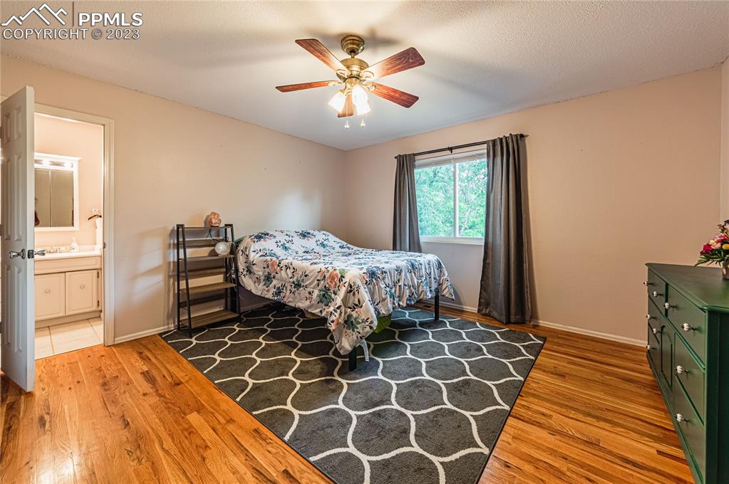 1917 Wooten Road Colorado Springs, CO 80915 - Photo 23 of 35 a bedroom with a bed and a chandelier