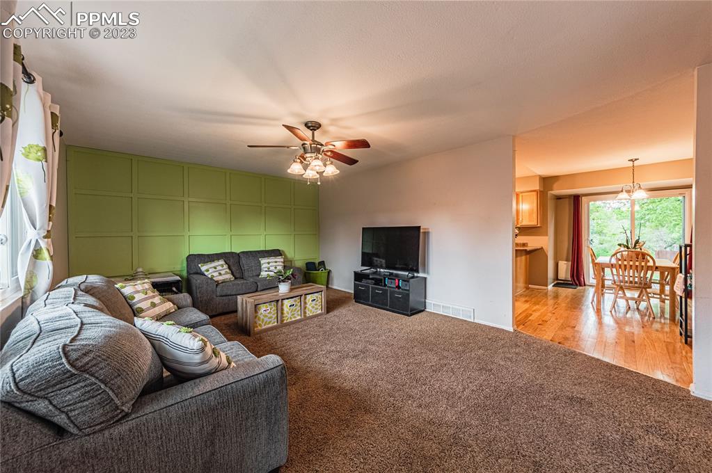 1917 Wooten Road Colorado Springs, CO 80915 - Photo 4 of 35 a living room with furniture and a flat screen tv