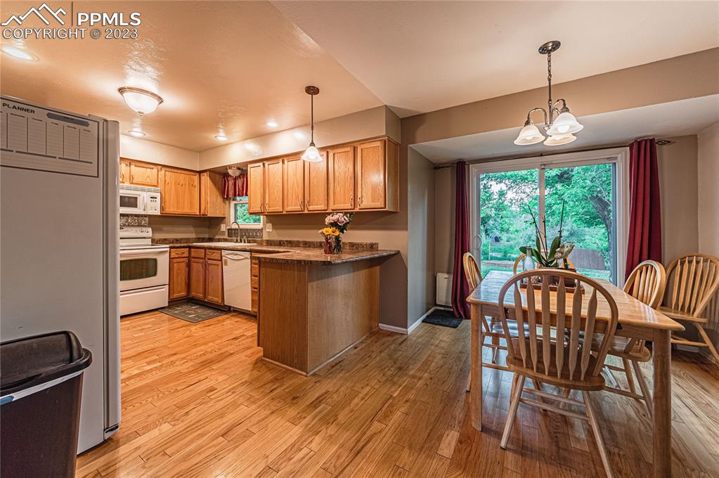 1917 Wooten Road Colorado Springs, CO 80915 - Photo 7 of 35 a kitchen with granite countertop wooden floors and stainless steel appliances