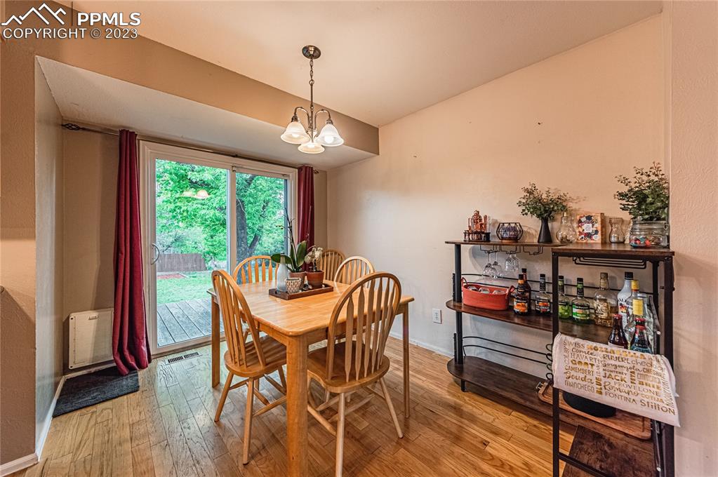 1917 Wooten Road Colorado Springs, CO 80915 - Photo 8 of 35 a view of a dining room with furniture window and wooden floor
