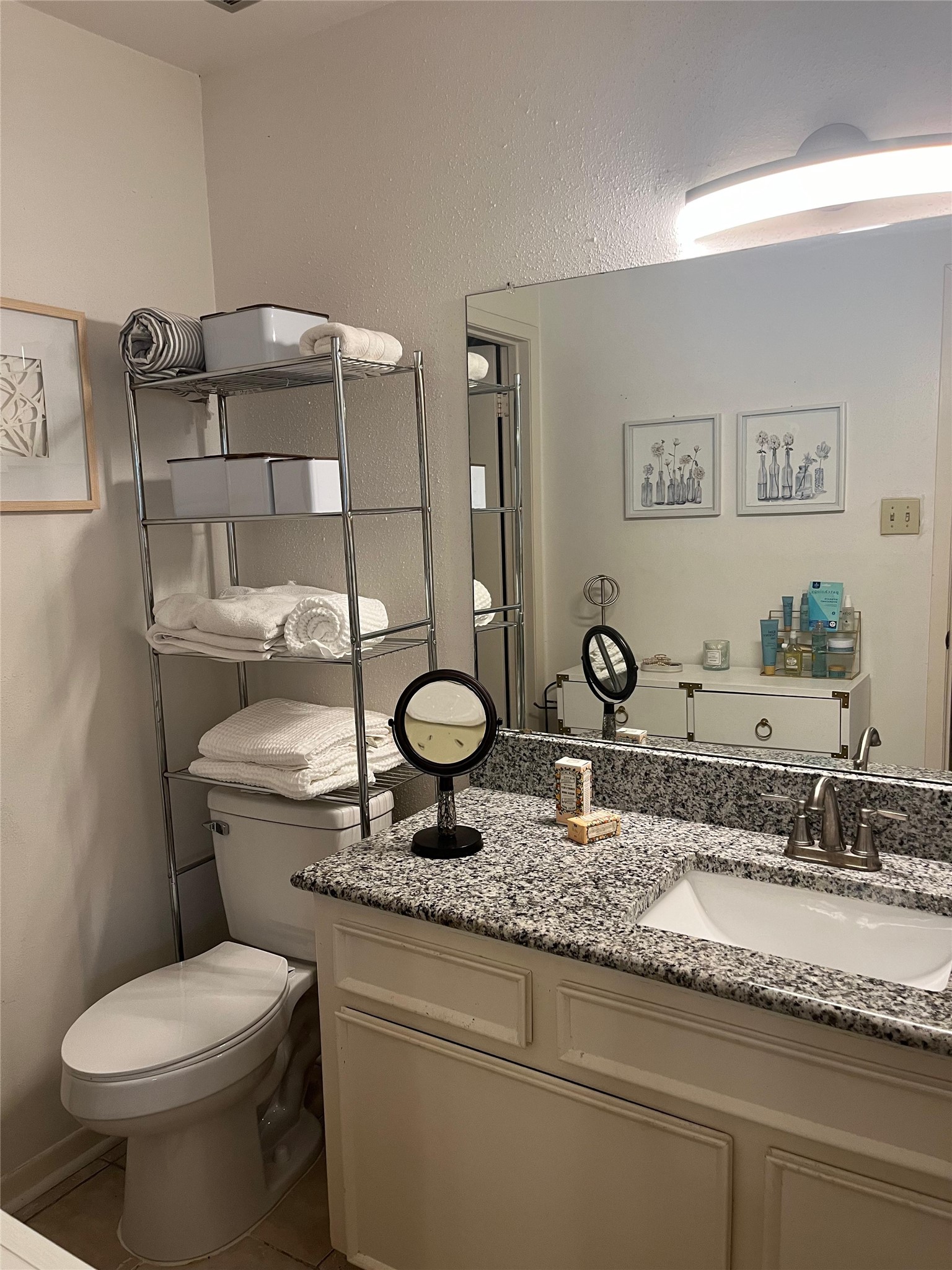 515 Tallowood Road, Unit 55 Houston, TX 77024 - Photo 13 of 18 a bathroom with a granite countertop toilet sink and mirror