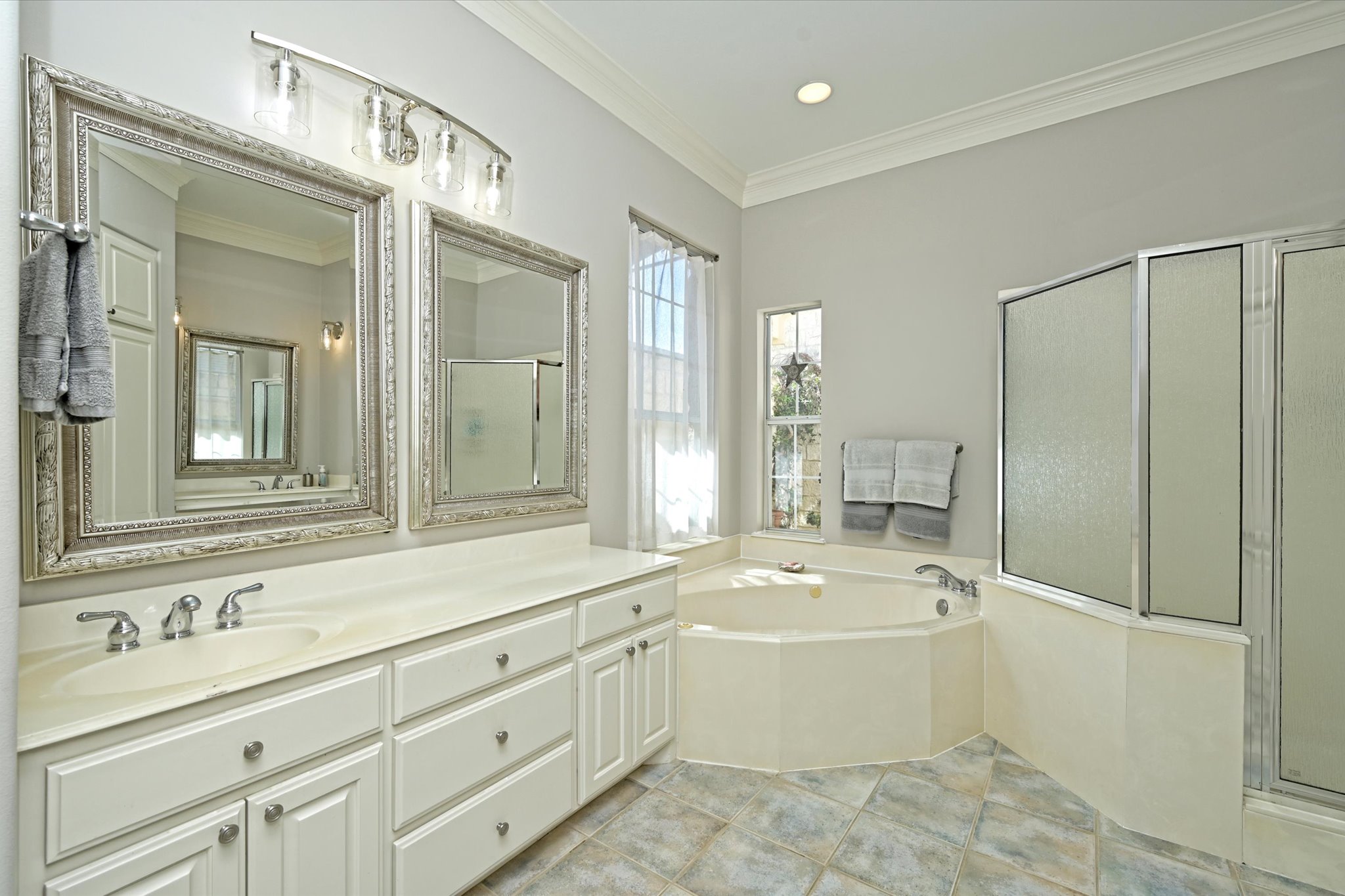 4912 Interlachen Lane Austin, TX 78747 - Photo 38 of 39 a bathroom with a bathtub a double vanity sink and mirror