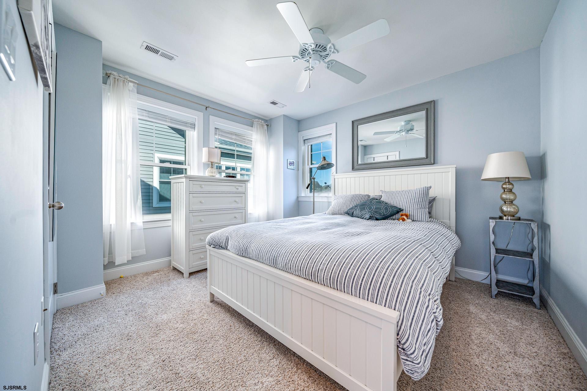 225 West Inlet Road Ocean City, NJ 08226 - Photo 24 of 56 a bedroom with a large bed and a chandelier