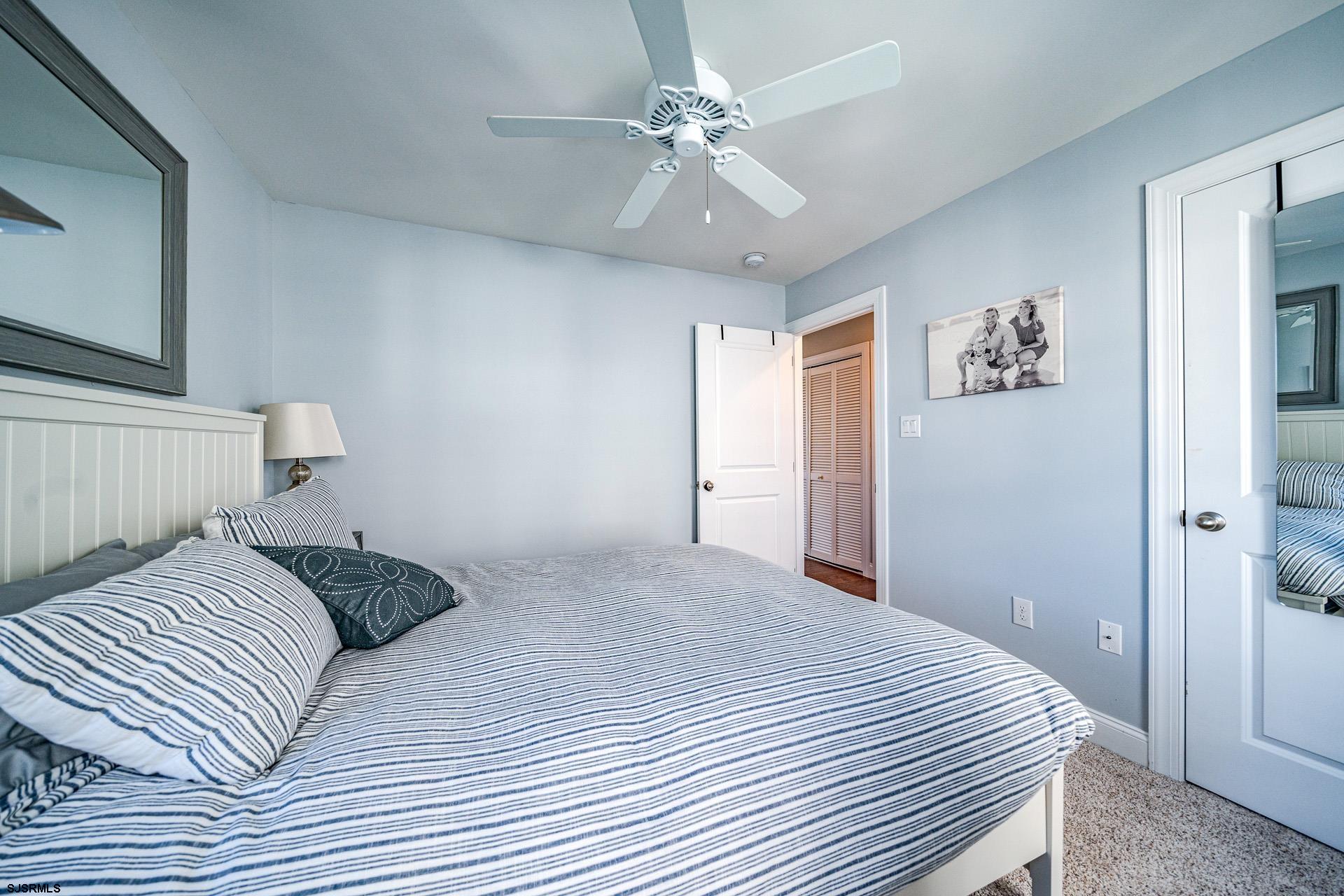 225 West Inlet Road Ocean City, NJ 08226 - Photo 25 of 56 a bedroom with a large bed and a chandelier