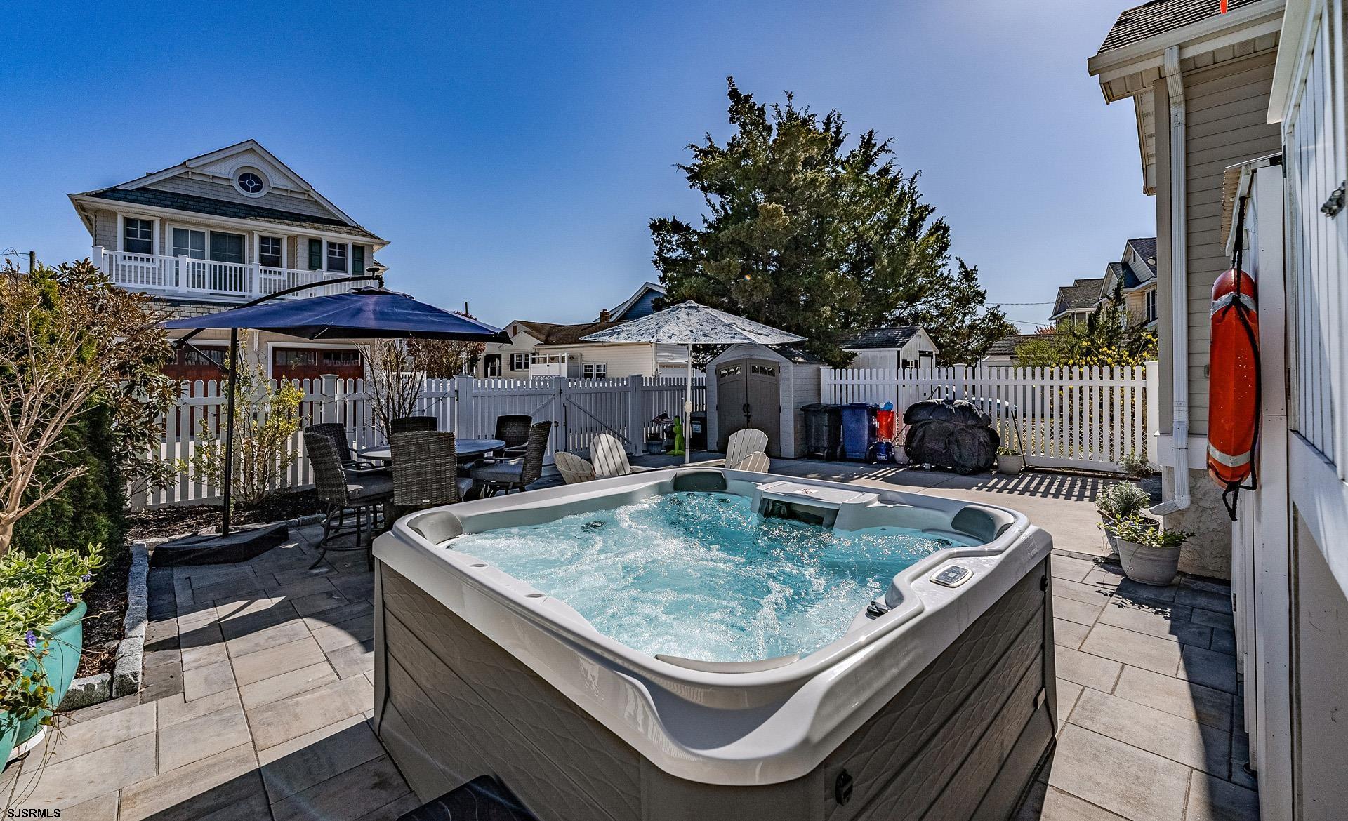 225 West Inlet Road Ocean City, NJ 08226 - Photo 33 of 56 a view of a patio with couches table and chairs under an umbrella with a fire pit