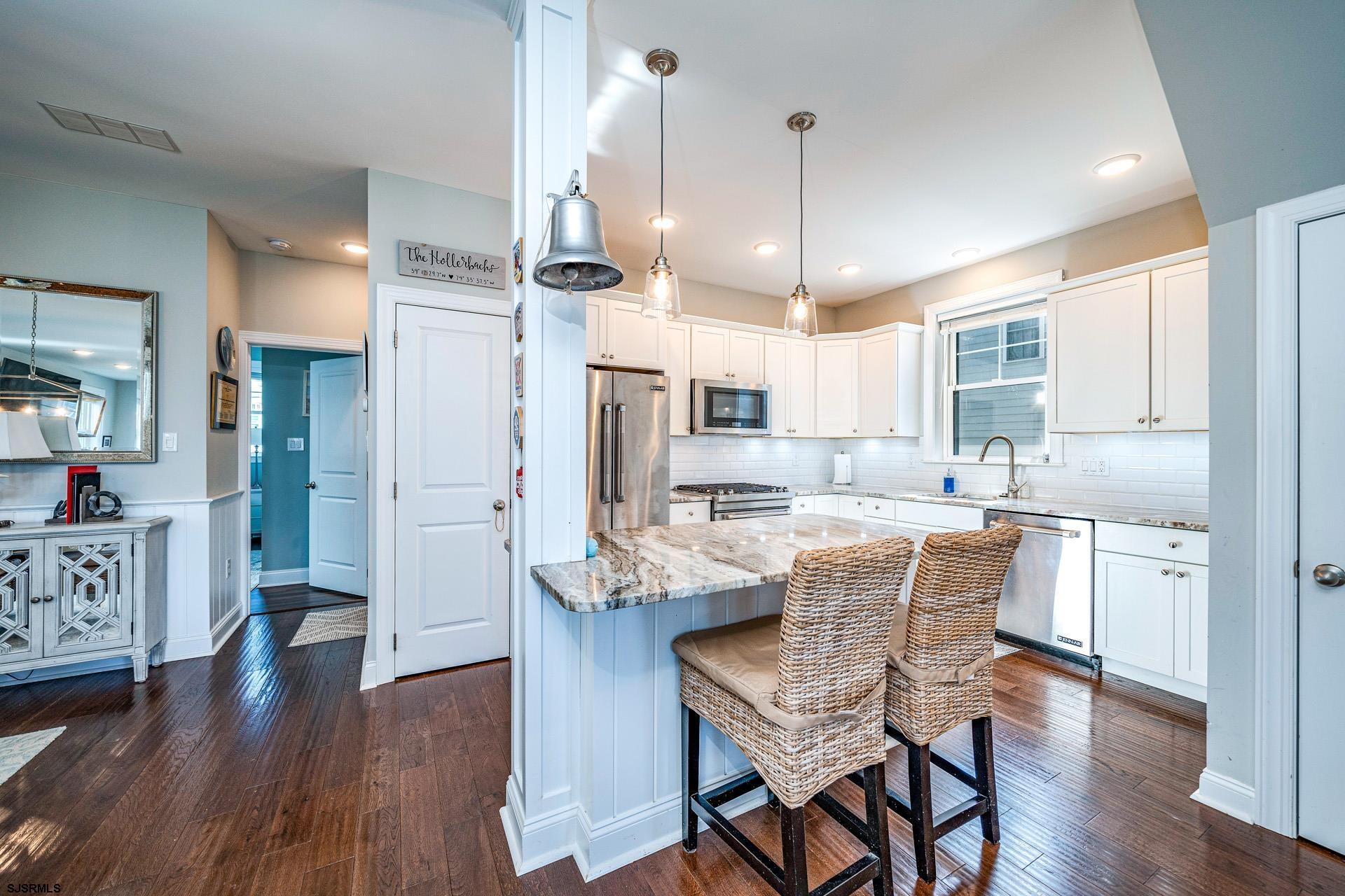225 West Inlet Road Ocean City, NJ 08226 - Photo 10 of 56 a kitchen with stainless steel appliances kitchen island granite countertop a table chairs and a refrigerator