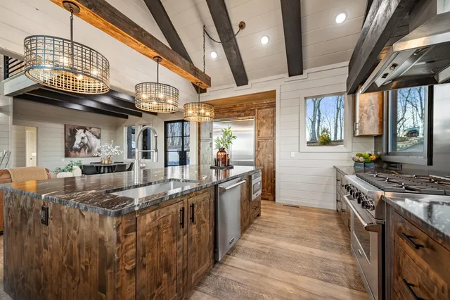 a kitchen with stainless steel appliances granite countertop a sink and stove