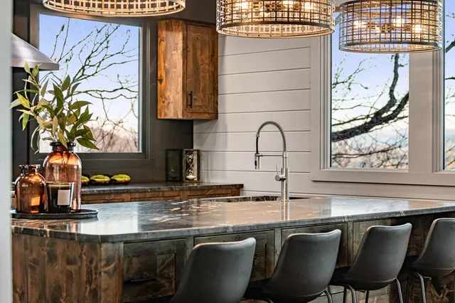 a kitchen with a table chairs and a potted plant