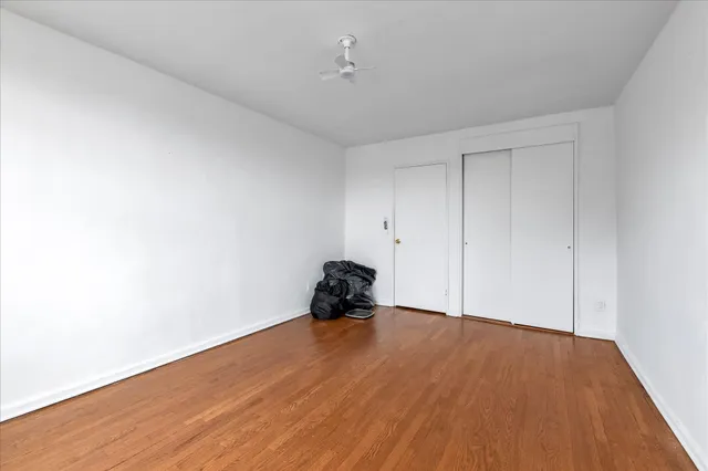 a room with wooden floor and ceiling fan