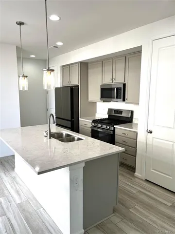 a kitchen with kitchen island white cabinets and stainless steel appliances