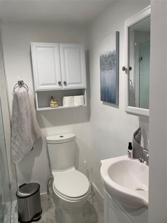 5601 Northwest 2nd Avenue, Unit 3190 Boca Raton, FL 33487 - Photo 9 of 16 a bathroom with a toilet sink and mirror