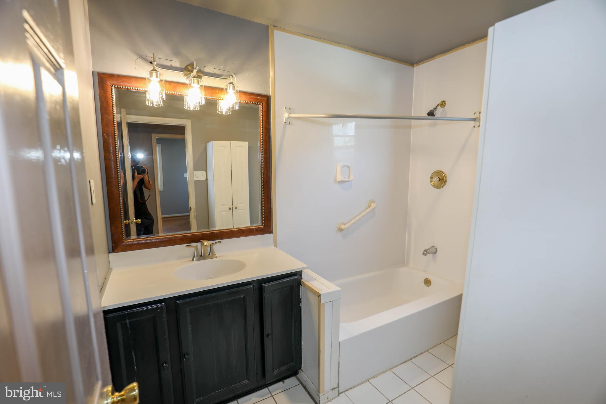 103 R Waelchli Avenue Halethorpe, MD 21227 - Photo 26 of 37 a bathroom with a sink tub vanity and a mirror