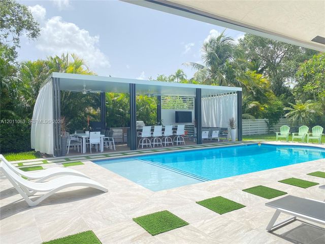 a view of a house with swimming pool and sitting area