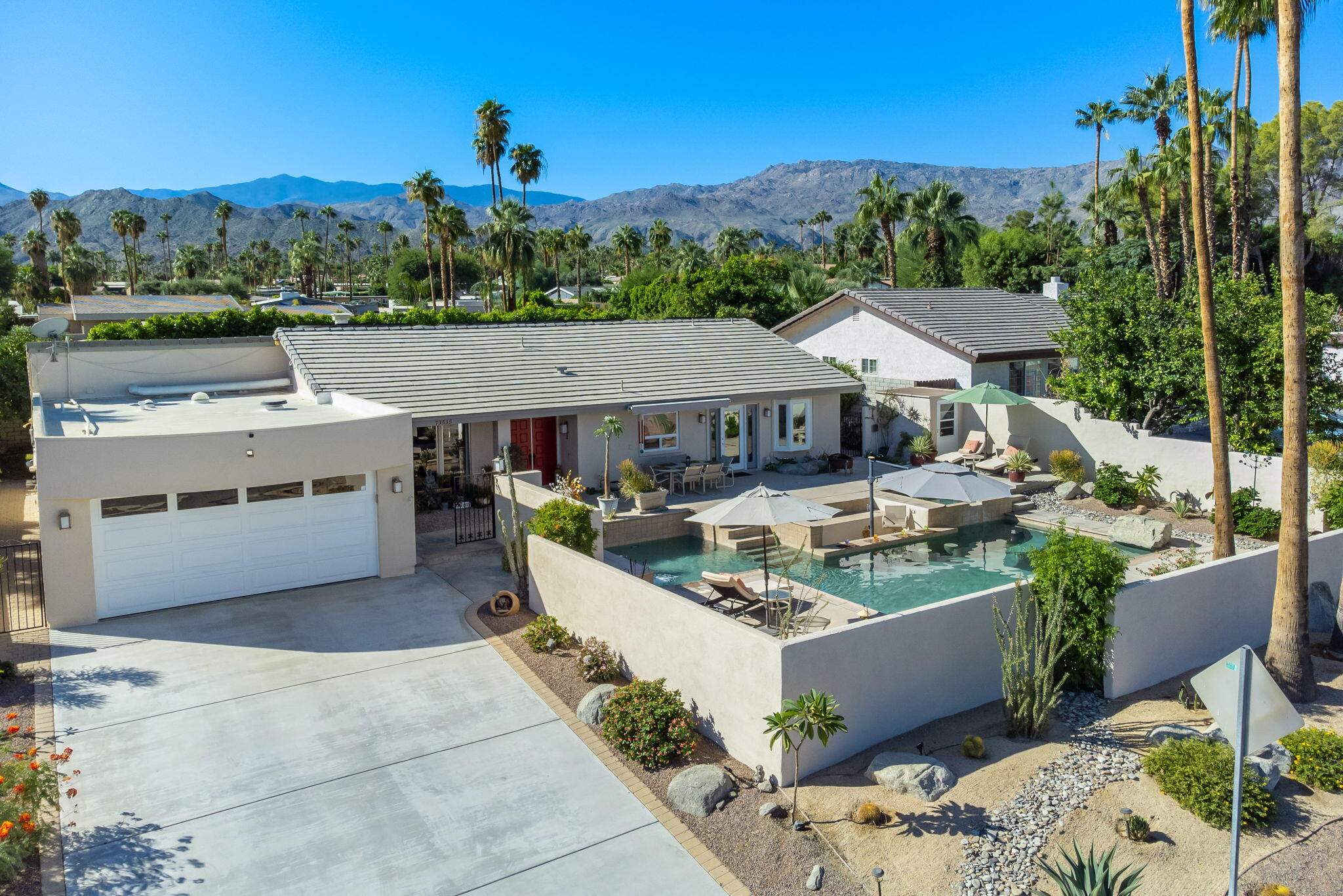 73535 Haystack Road Palm Desert, CA 92260 - Photo 4 of 47 a view of a patio with couches table and chairs under an umbrella