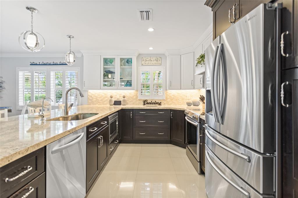 1650 Northeast 27th Avenue Pompano Beach, FL 33062 - Photo 18 of 90 a kitchen with stainless steel appliances granite countertop a refrigerator a sink a stove and a microwave