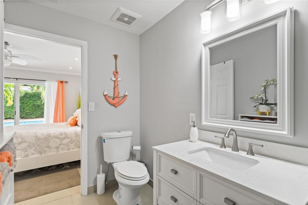 1650 Northeast 27th Avenue Pompano Beach, FL 33062 - Photo 31 of 90 a bathroom with a sink a toilet and a mirror