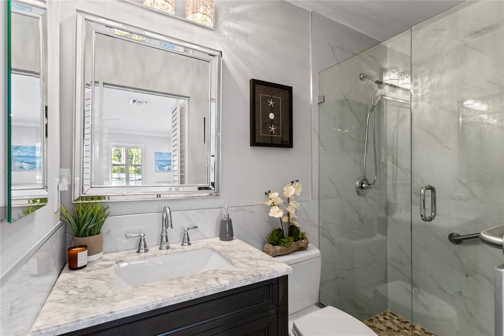 1650 Northeast 27th Avenue Pompano Beach, FL 33062 - Photo 49 of 90 a bathroom with a granite countertop sink a toilet a mirror and shower