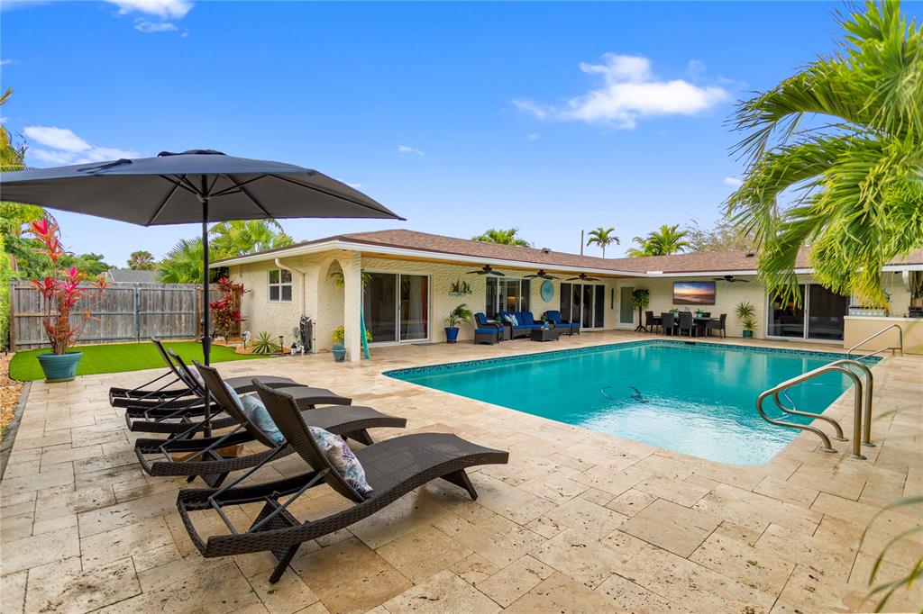 1650 Northeast 27th Avenue Pompano Beach, FL 33062 - Photo 63 of 90 a view of pool with lawn chairs under an umbrella