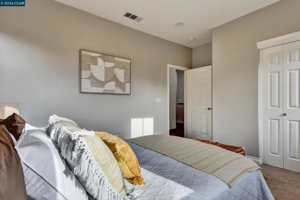 a bedroom with a bed and a painting on the wall