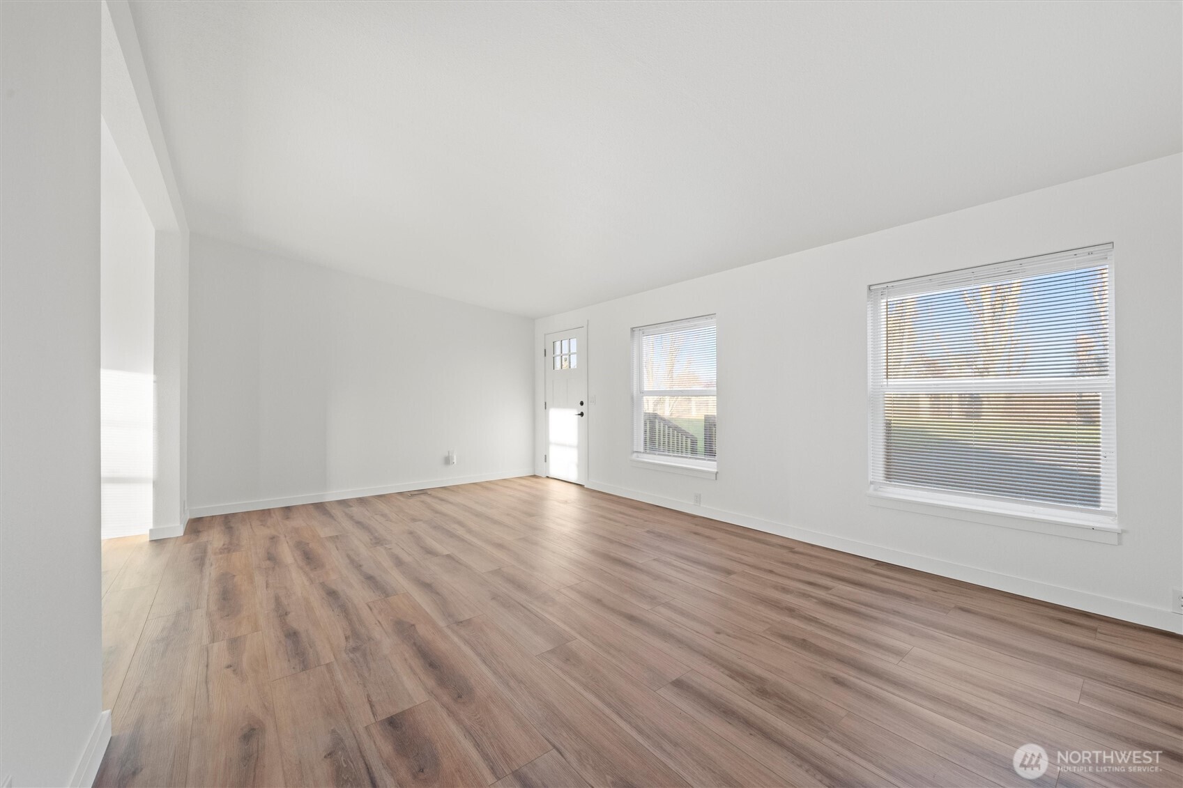 2326 Stoneridge Road Northeast Moses Lake, WA 98837 - Photo 11 of 37 an empty room with wooden floor and windows
