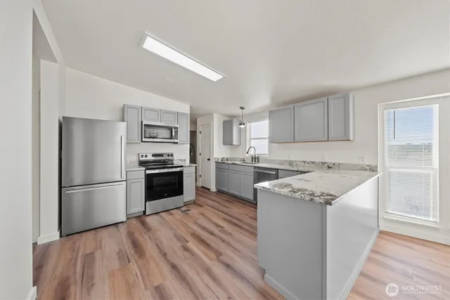 a kitchen with a refrigerator stove and white cabinets