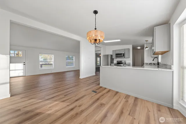 a view of a room with wooden floor and kitchen view