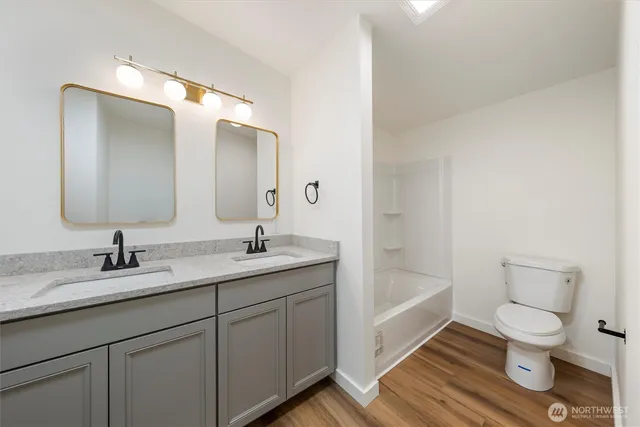 a bathroom with a granite countertop sink toilet and a mirror