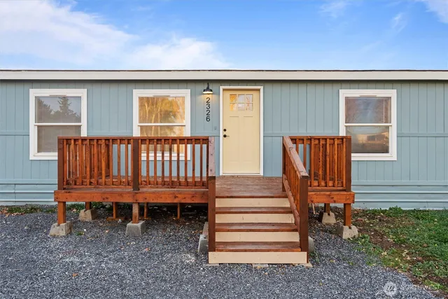 a view of a backyard with wooden fence and a bench