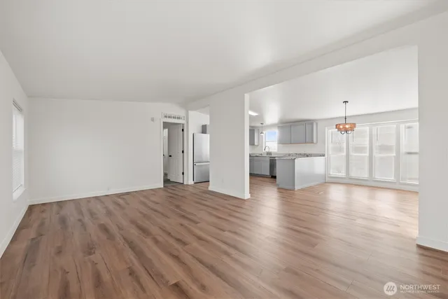 a view of empty room with wooden floor and windows