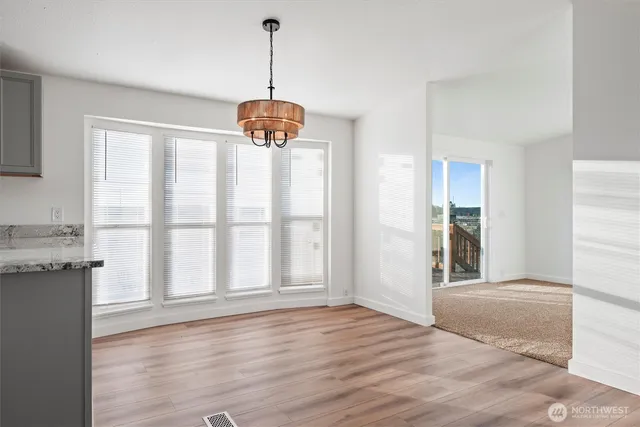 a view of empty room with wooden floor and window