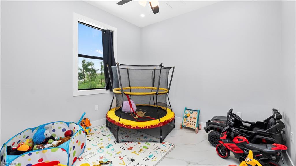 4571 22nd Street Northeast Naples, FL 34120 - Photo 17 of 47 Playroom featuring light marble finish flooring and a ceiling fan