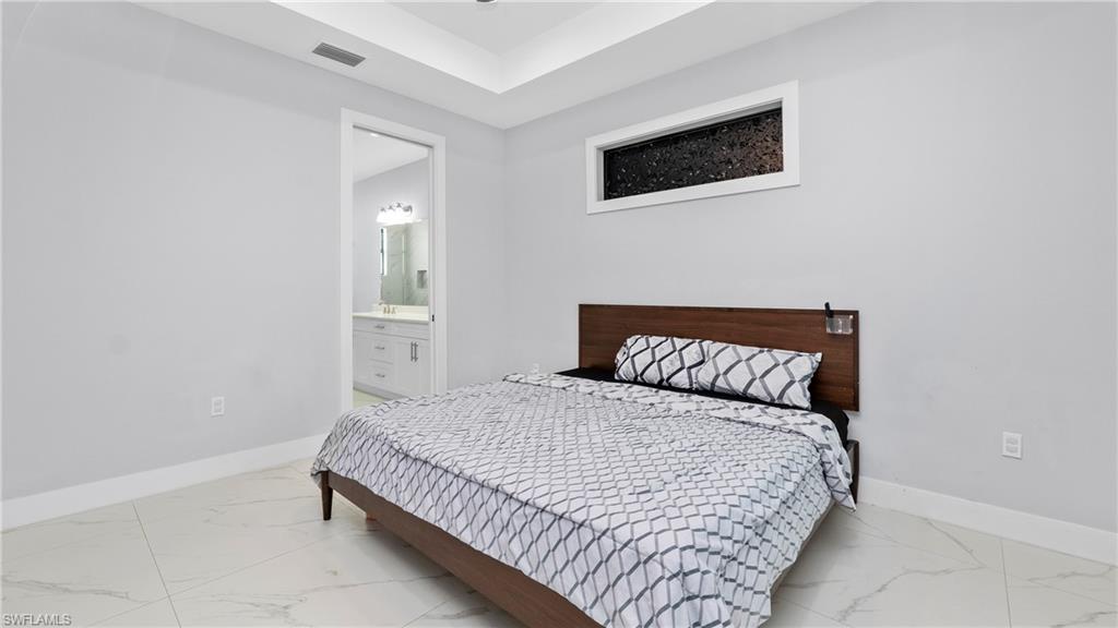 4571 22nd Street Northeast Naples, FL 34120 - Photo 18 of 47 Bedroom with ensuite bathroom and light marble finish floors