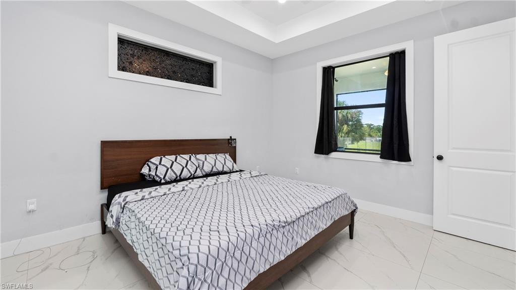 4571 22nd Street Northeast Naples, FL 34120 - Photo 19 of 47 Bedroom with baseboards and light marble finish flooring