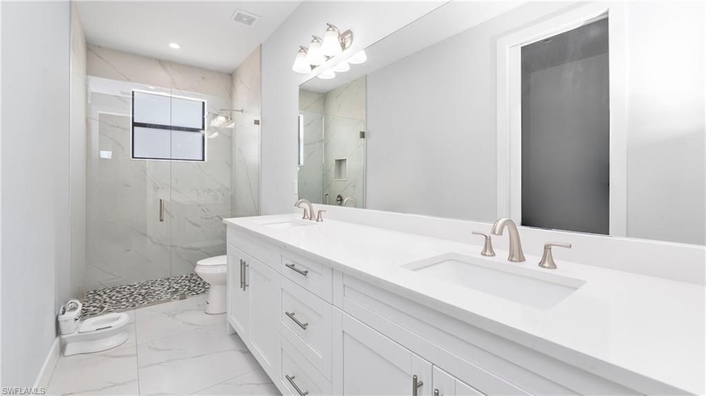 4571 22nd Street Northeast Naples, FL 34120 - Photo 27 of 47 Bathroom featuring double vanity, a marble finish shower, light marble finish flooring, and recessed lighting