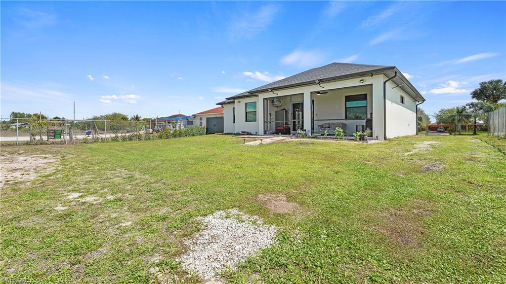 4571 22nd Street Northeast Naples, FL 34120 - Photo 38 of 47 Rear view of house featuring a fenced backyard, a ceiling fan, stucco siding, and a patio area