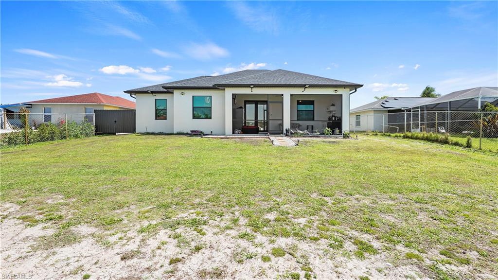 4571 22nd Street Northeast Naples, FL 34120 - Photo 39 of 47 Rear view of property featuring a sunroom, a fenced backyard, and stucco siding